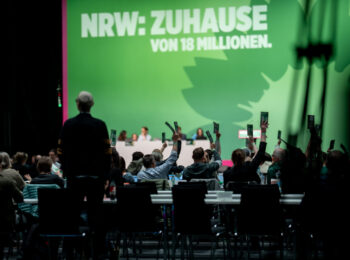 Delegierte stimmen über einen Antrag auf dem Parteitag der GRÜNEN NRW in Köln 2025 ab.