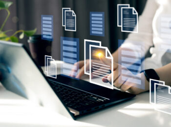 Person tippt auf Laptop. Eingeblendet sind digitale Dokumente.
